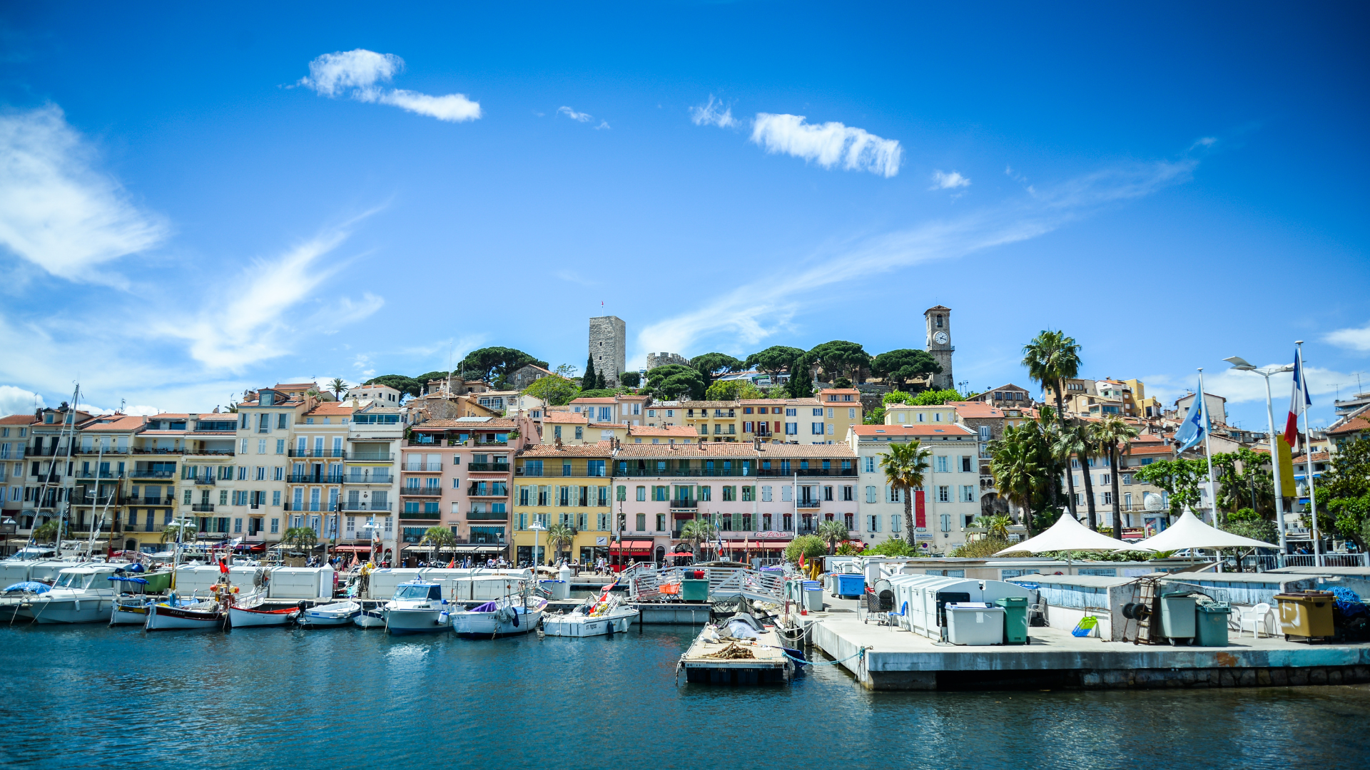 Vieux port et vieille ville d'une commune de la Côte d'Azur, avec bateaux de plaisance amarrés.